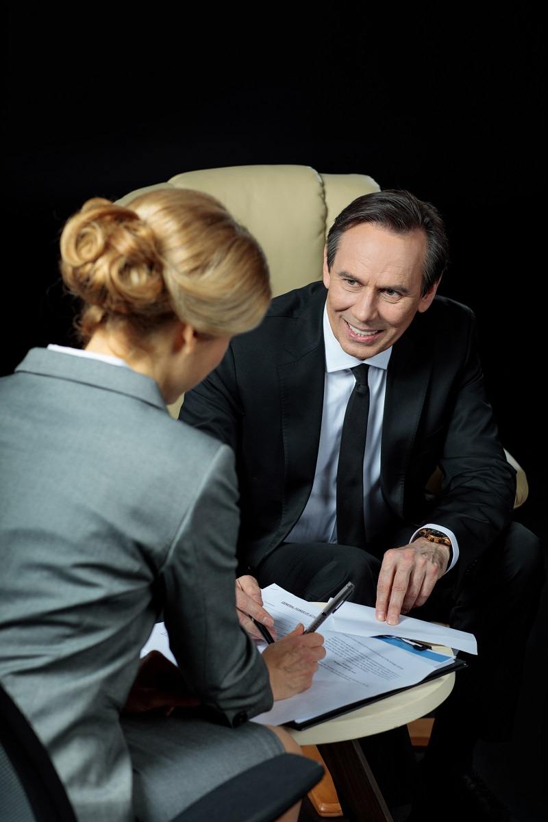 smiling-mature-businessman-looking-at-blonde-busin-2023-11-27-04-49-21-utc