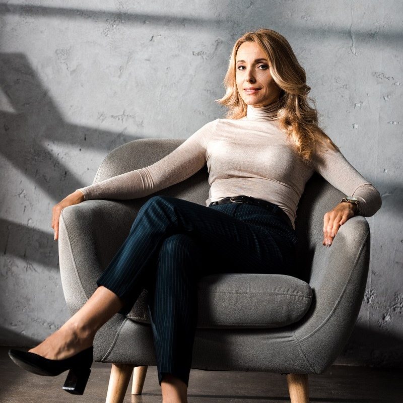 attractive-and-blonde-businesswoman-smiling-and-si-2023-11-27-05-35-03-utc